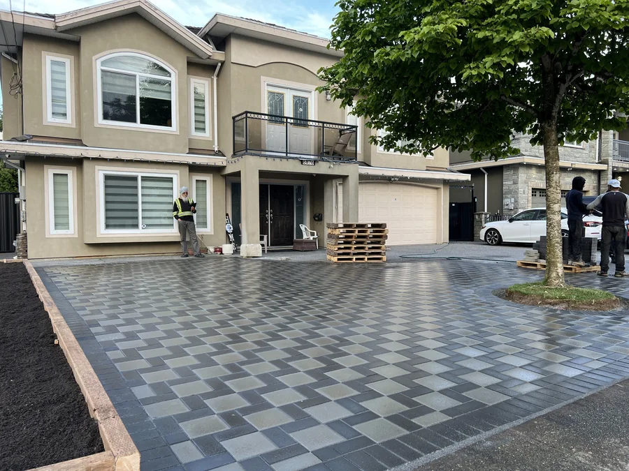 Two-storey home with a two-tone checkerboard paver driveway.